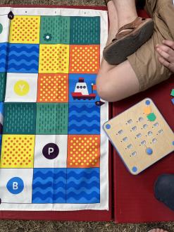  Kinder sitzen auf dem Boden und programmieren