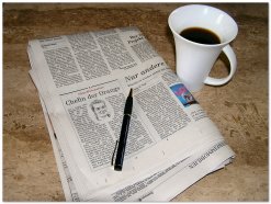 Zeitung, Stift und Kaffeetasse