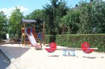 rote Wipptiere vor Rutschenturm im Sandkasten auf dem Spielplatz Ahornweg / Pappelweg