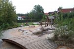 Wasseranlage mit Holzbrücke auf dem Spielplatz Karlsbader Straße