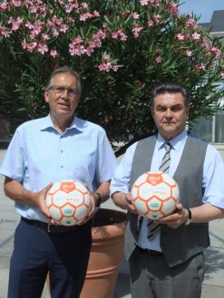 Bürgermeister Jürgen Herzing und Oberbürgermeister Klaus Herzog präsentieren den unter fairen Arbeitsbedingungen hergestellten Ball mit der Aufschrift „Aschaffenburg spielt fair“.