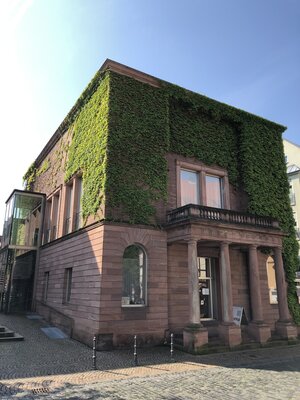 Bild vergr&ouml;&szlig;ern: Das Sitzungssaalgebäude in Aschaffenburg steht direkt neben dem Rathaus. Die Fassade ist begrünt. Es steht unter Denkmalschutz.