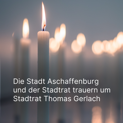 Kerzen leuchten, grauer Hintergrund. Trauer um Stadtrat Thomas Gerlach. 