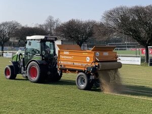 Bild vergr&ouml;&szlig;ern: Mit einemTraktor mit Anhänger streut das Gartenamt Sand auf die Rasensportplätze.