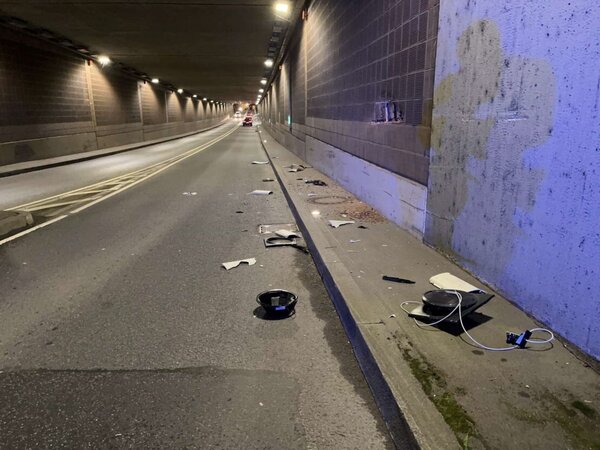 Sachschaden an Tunneltechnik nach einem Unfall. Elektroteile liegen auf der Fahrbahn, Wand ist beschädigt. 