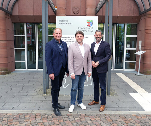 Oberbürgermeister Markus Schlemmer, Landrat Björn Bartels und Landrat Dr. Alexander Legler vor dem Landratsamt Aschaffenburg. 