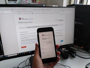 Bild vergr&ouml;&szlig;ern: Smartphone und Computerbildschirm mit Antrag für denkmalrechtliche Erlaubnisanträge und Grabungserlaubnisse