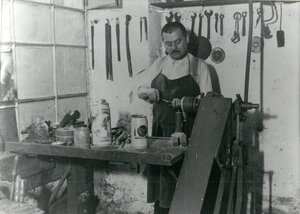Bild vergr&ouml;&szlig;ern: Zinngießer Johann Brandmüller an seiner Werkbank, um 1912